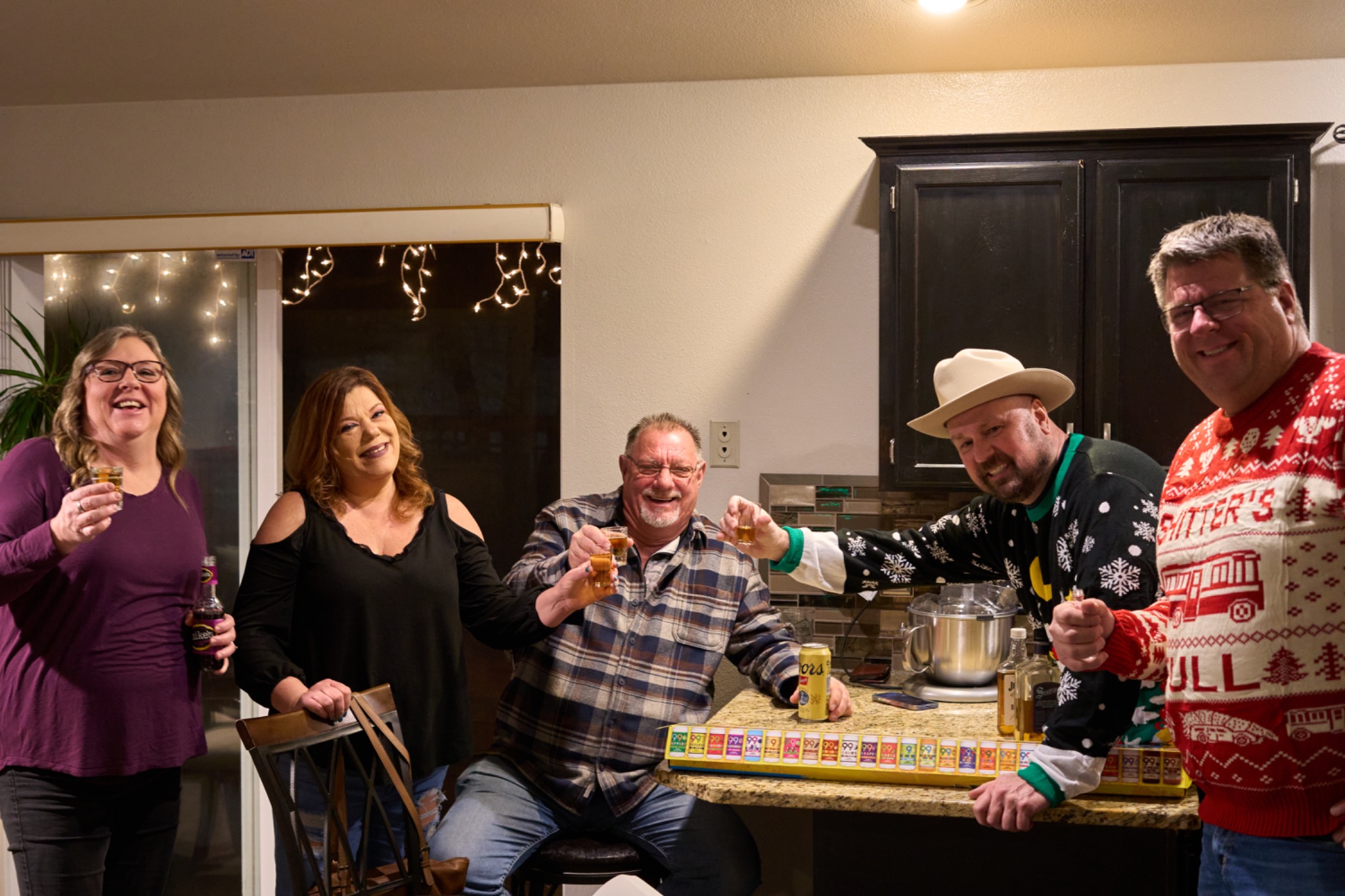 Friends raising a toast in a kitchen at Christmas